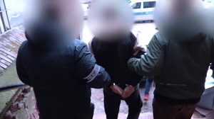 Policjanci prowadzą zatrzymanego