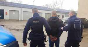 Policjanci prowadzą zatrzymanego
