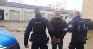 Policjanci prowadzą zatrzymanego