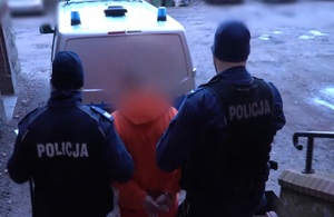 Policjanci prowadzą zatrzymanego