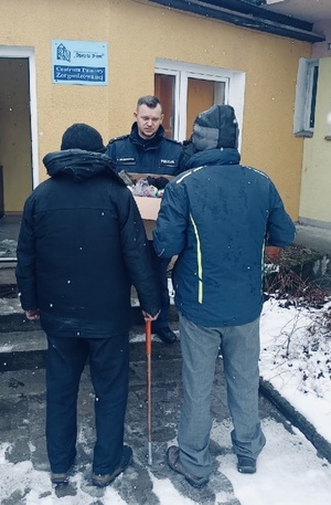 Dzielnicowy podczas przekazania paczki