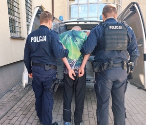 zatrzymany mężczyzna prowadzony przez policjantów