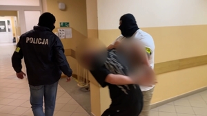 zatrzymany mężczyzna prowadzony przez policjantów