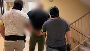 zatrzymany mężczyzna prowadzony przez policjantów