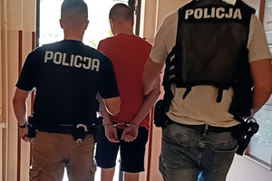 Zatrzymany mężczyzna prowadzony przez policjantów