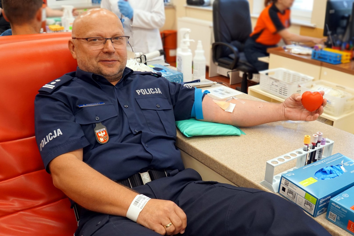 Policjant siedzący na fotelu podczas poboru krwi