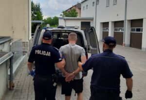 Policjanci prowadzą zatrzymanego