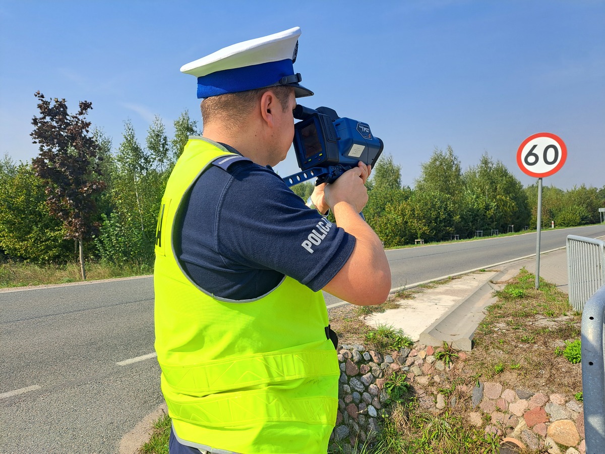 Zdjęcie przedstawia policjanta podczas kontroli prędkości.