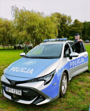 Zdjęcie przedstawia policjantkę obok radiowozu.