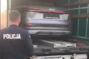 Policjant przy naczepie z autem