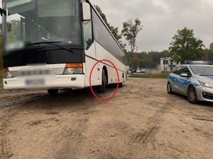 Zdjęcie przedstawia autobus oraz policyjny radiowóz.