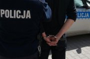 Zdjęcie przedstawia fragment policjanta i osobę zatrzymaną.