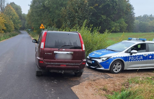 Zdjęcie przedstawia auto oraz policyjny radiowóz.