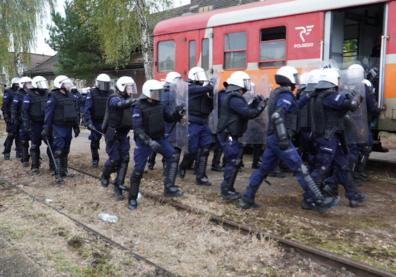 Policjanci podczas ćwiczeń wchodzący do pociągu.