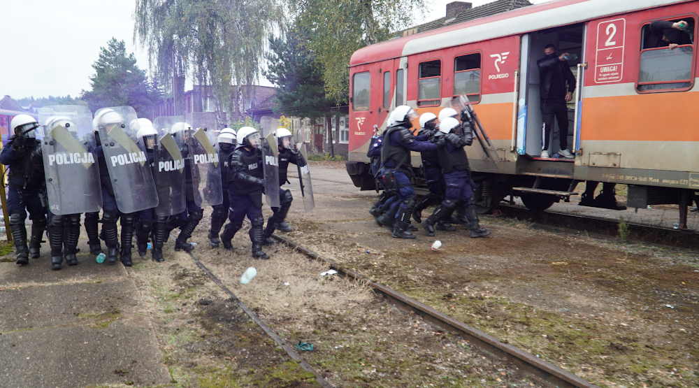 Policjanci podczas ćwiczeń wchodzący do pociągu.