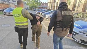 Zatrzymany mężczyzna prowadzony przez policjantów