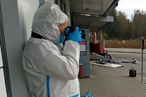 Technik kryminalistyki z aparatem przy twarzy