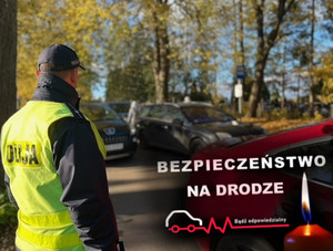 Policjant na cmentarzu obok zaparkowanych samochodów