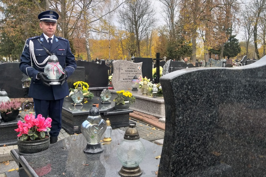 Policjanci na cmentarzu stojący przed grobami