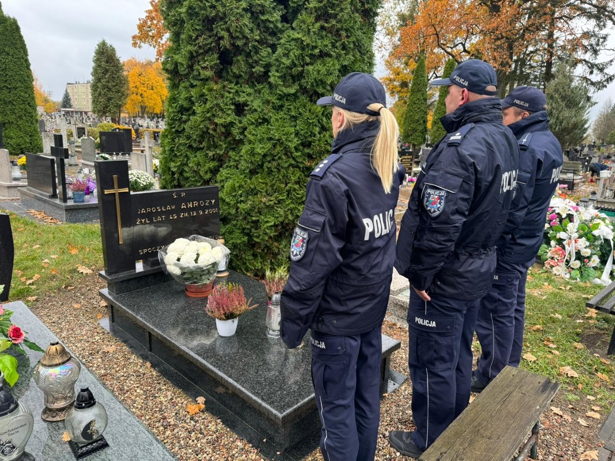 Policjanci na cmentarzu stojący przed grobami