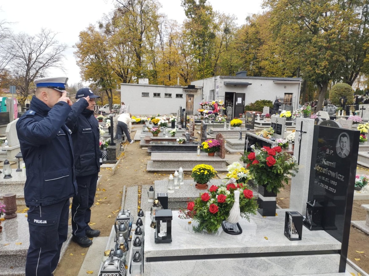 Policjanci na cmentarzu stojący przed grobami