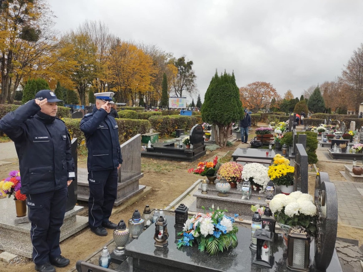 Policjanci na cmentarzu stojący przed grobami