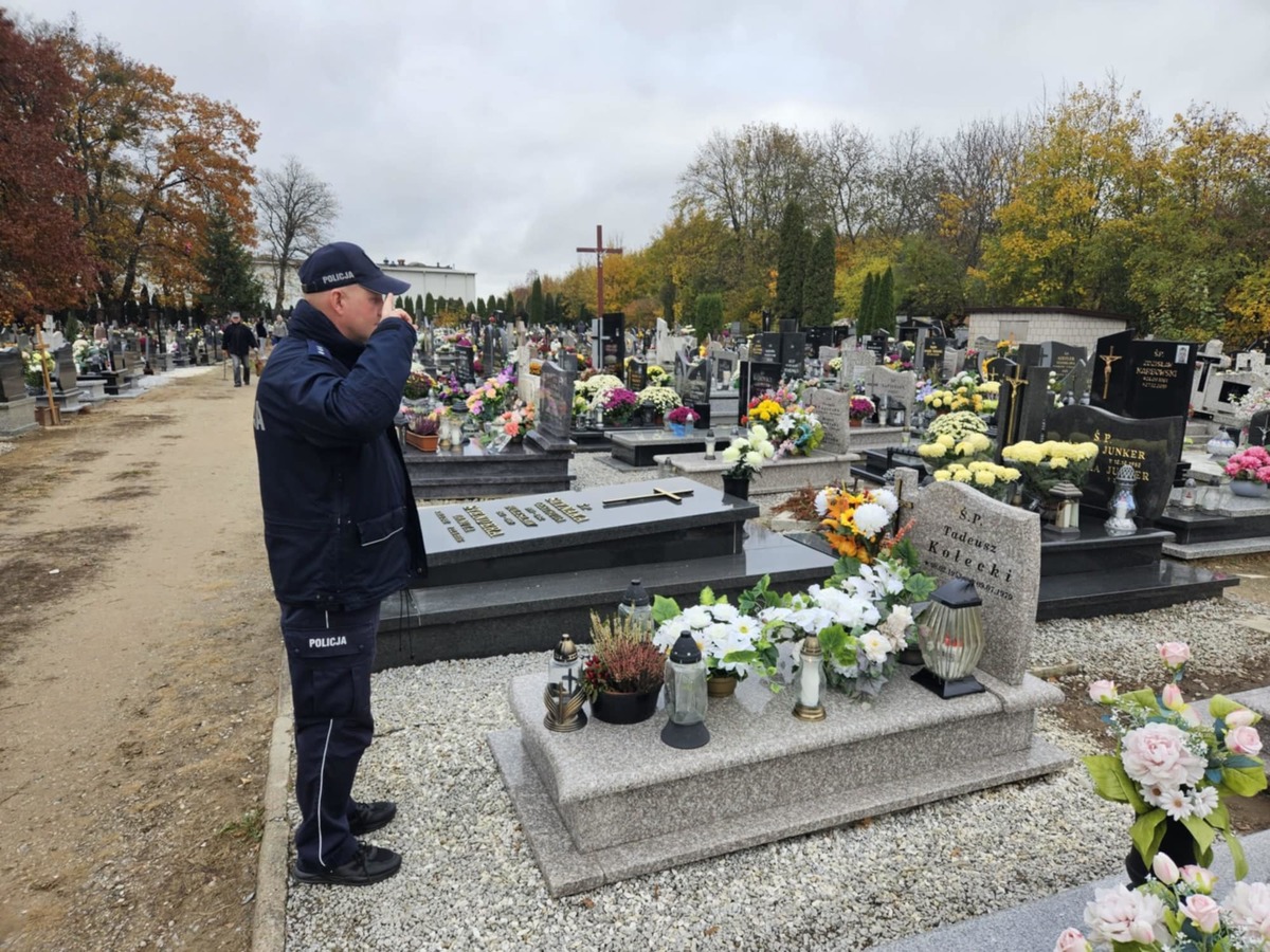 Policjanci na cmentarzu stojący przed grobami