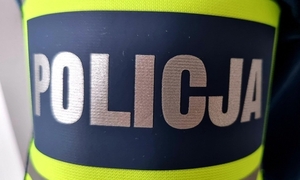 Zdjęcie przedstawia opaskę z napisem "Policja".