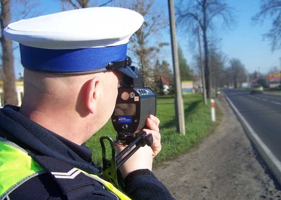 Zdjęcie przedstawia policjanta podczas kontroli prędkości.