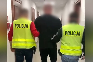 Zatrzymany mężczyzna prowadzony przez policjantów