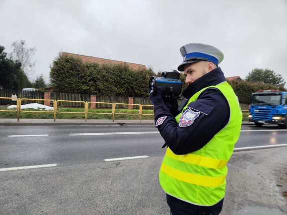 Zdjęcie przedstawia policjanta podczas kontroli drogowej.