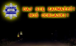 Napis: Daj się zauważyć! Noś odblaski! 
W tle osoby z kamizelkami odblaskowymi na drodze.