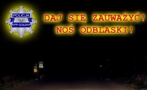 Napis: Daj się zauważyć! Noś odblaski! 
W tle osoby z kamizelkami odblaskowymi na drodze.