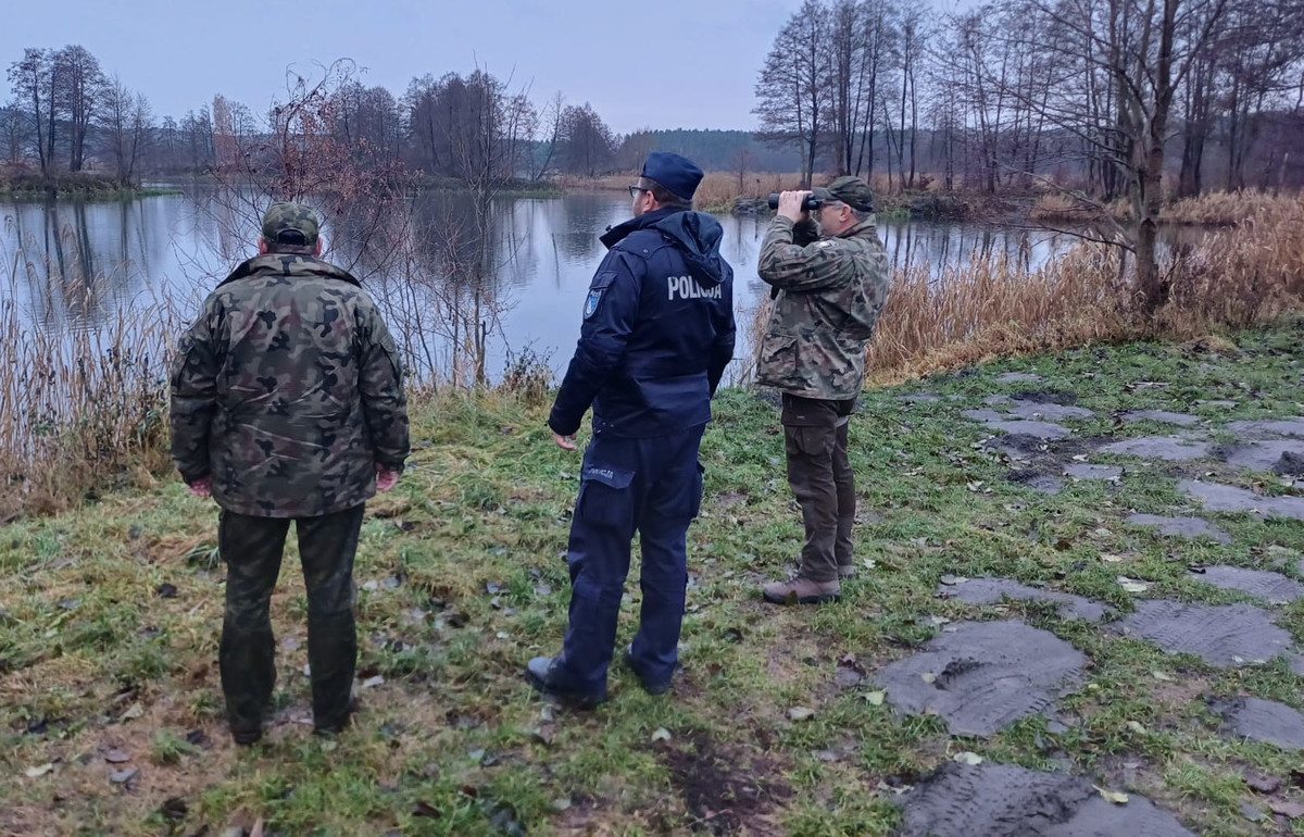 Zdjęcie przedstawia policjanta i strażników rybackich.