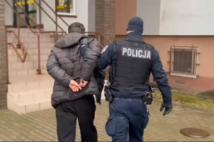 Prowadzenie zatrzymanego mężczyzny przez umundurowanego policjanta.