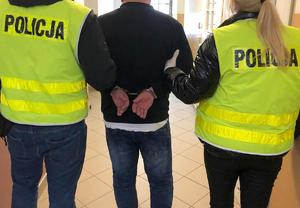 policjanci prowadzą zatrzymanego