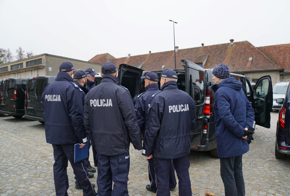 Policjanci przy autach służbowych