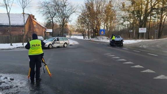 Policjanci pracujący na miejscu zdarzenia drogowego.