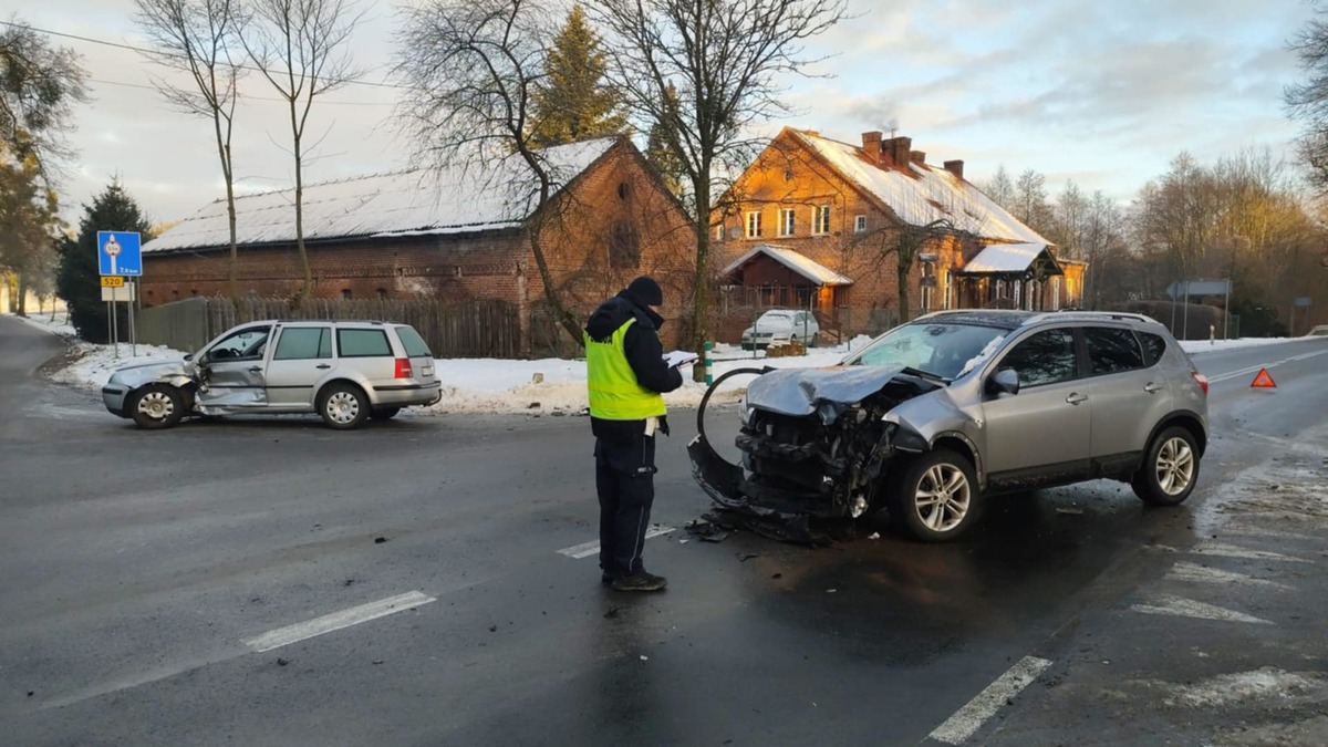 Policjanci pracujący na miejscu zdarzenia drogowego.