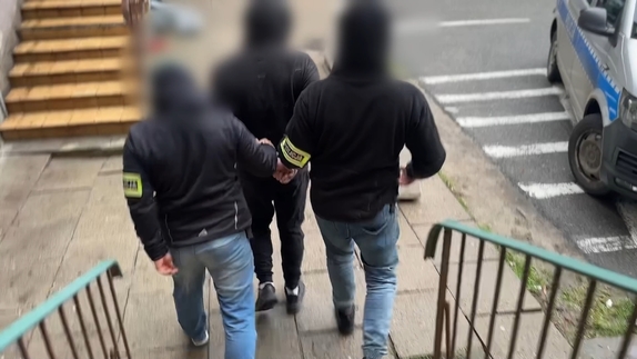 zatrzymany mężczyzna prowadzony przez policjantów