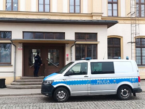 Radiów, policjant wchodzący do budynku.