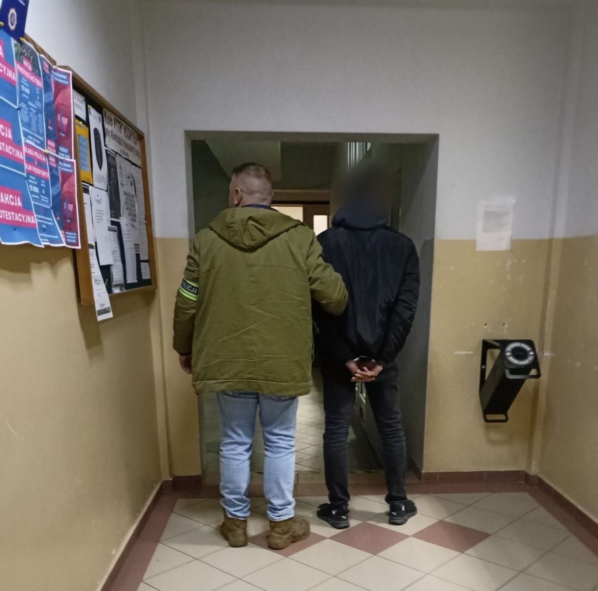 policjant prowadzi zatrzymanego