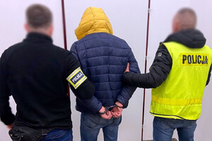 Zatrzymany mężczyzna prowadzony przez policjantów