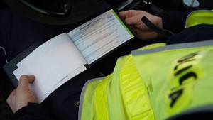 Policjant wypisujący mandat karny.