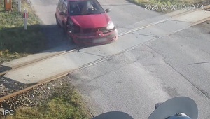 Uszkodzone auto przejeżdżające przez przejazd kolejowy.