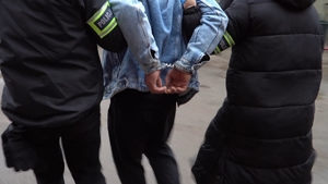 zatrzymany mężczyzna prowadzony przez policjantów