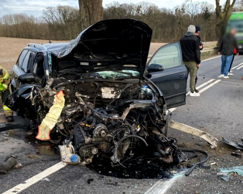 Miejsce zdarzenia drogowego. Uszkodzony pojazd oraz służby na miejscu.