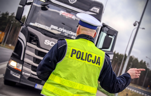 Policjant przed ciężarówką.