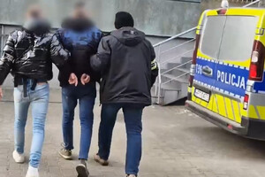 Zatrzymany mężczyzna prowadzony przez policjantów