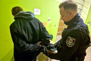 Zatrzymany mężczyzna prowadzony przez policjanta
